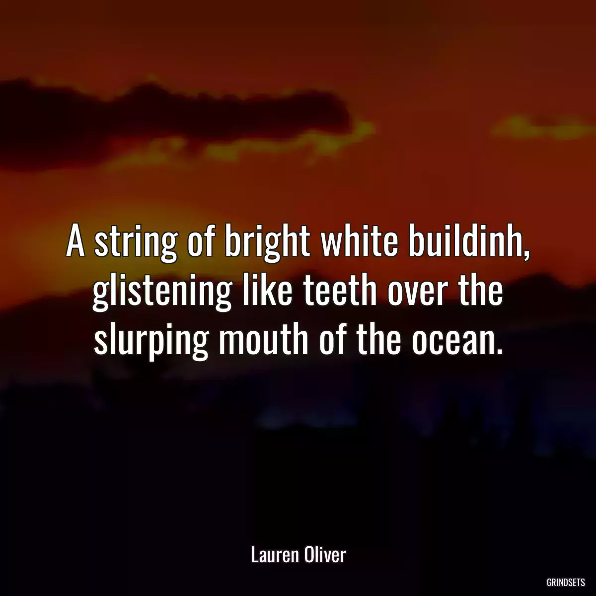 A string of bright white buildinh, glistening like teeth over the slurping mouth of the ocean.